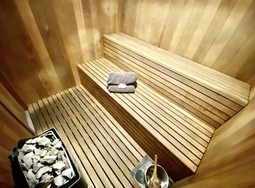 Birdseye view of MiGym's private cedar steam sauna, stones and a folded towel on the bench